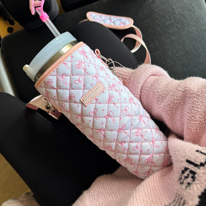 Coconut Lane tumbler with Ballet Slippers Straw Cover in a quilted pink case, held by someone in a pink sweater.