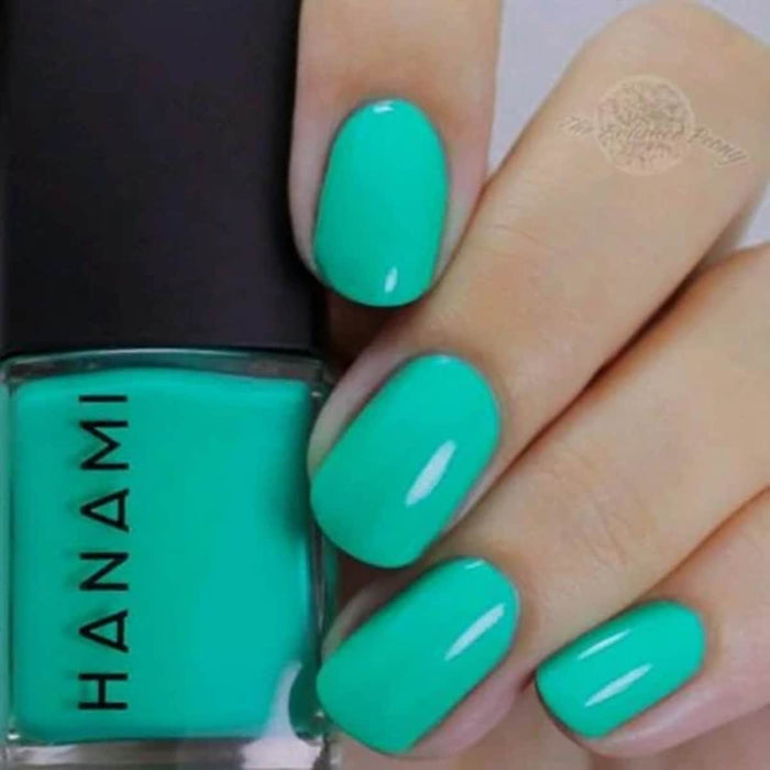 Turquoise nail polish with a hand holding the bottle labeled 'HANAMI'.