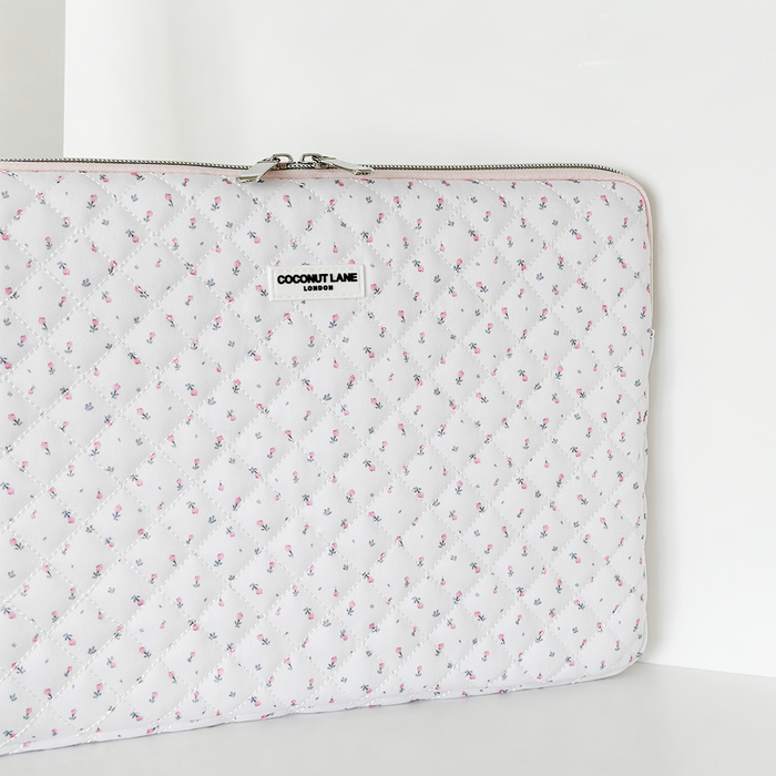 White quilted laptop sleeve with small pink and blue floral pattern.