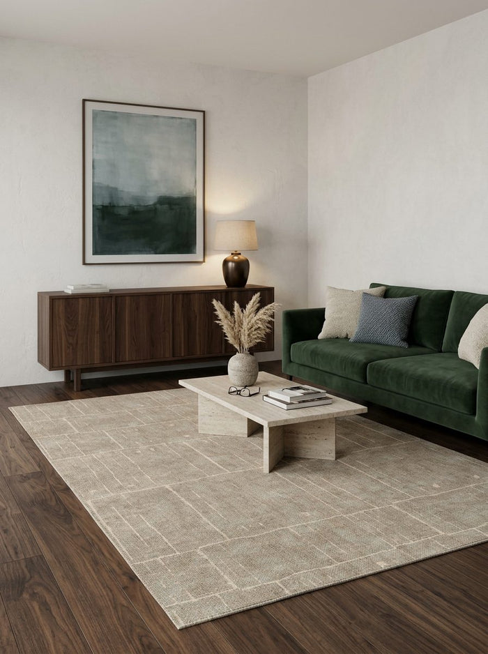 Beige rug with a subtle grid pattern, styled in a modern living room with a green sofa and dark wood furniture.