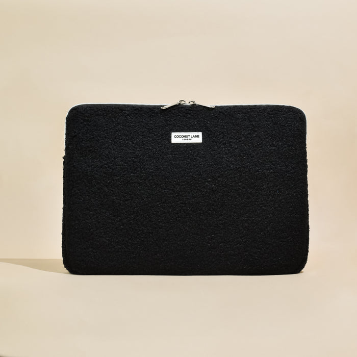Black textured laptop sleeve with zipper and small white label, designed by Coconut Lane.