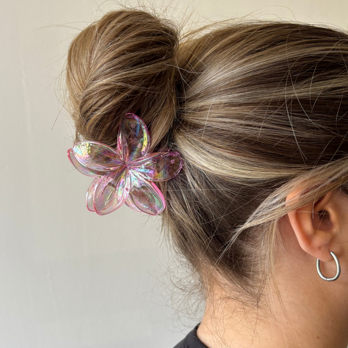 Blonde hair in a bun held by Coconut Lane holographic pink Tropical Flower claw clip.