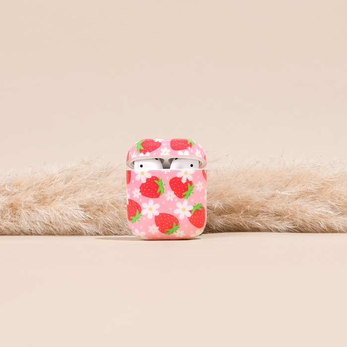 Pink Airpods case with a flower and strawberry pattern, shown holding white wireless earbuds.