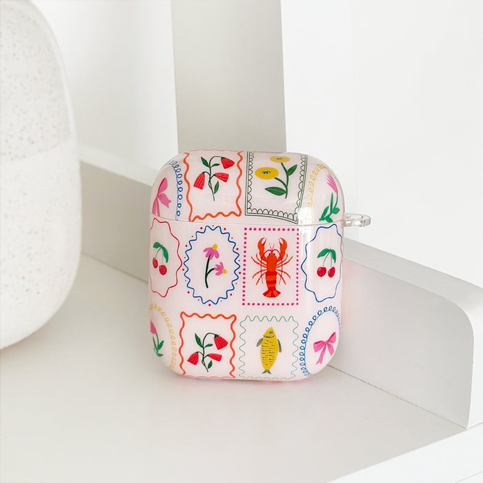 White Coconut Lane AirPods case with colorful flower and lobster illustrations.