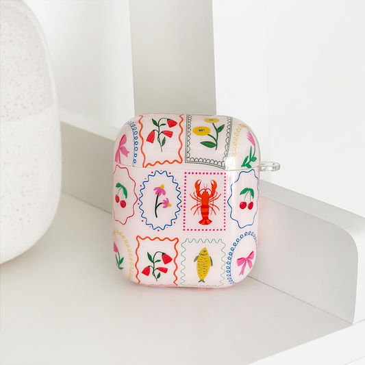 White Coconut Lane AirPods case with colorful flower and lobster illustrations.