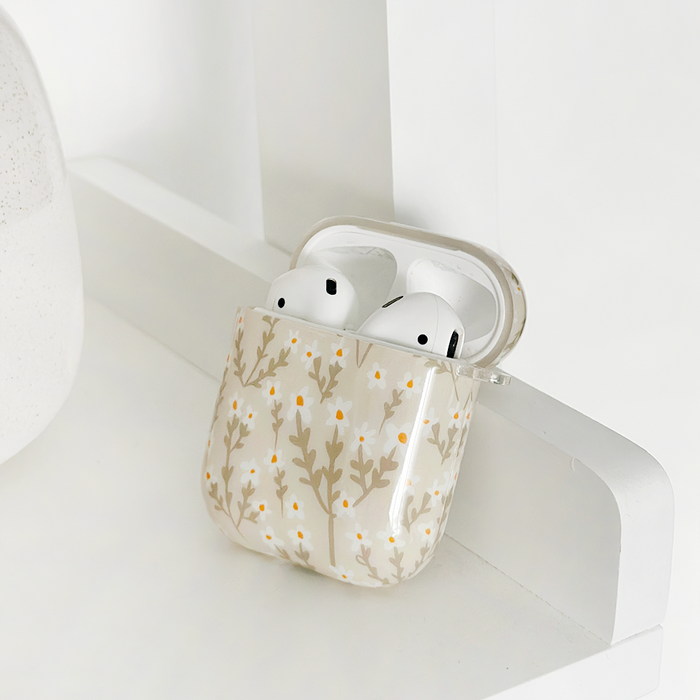 White wireless earbuds in a Coconut Lane AirPods case featuring a nude flower pattern.