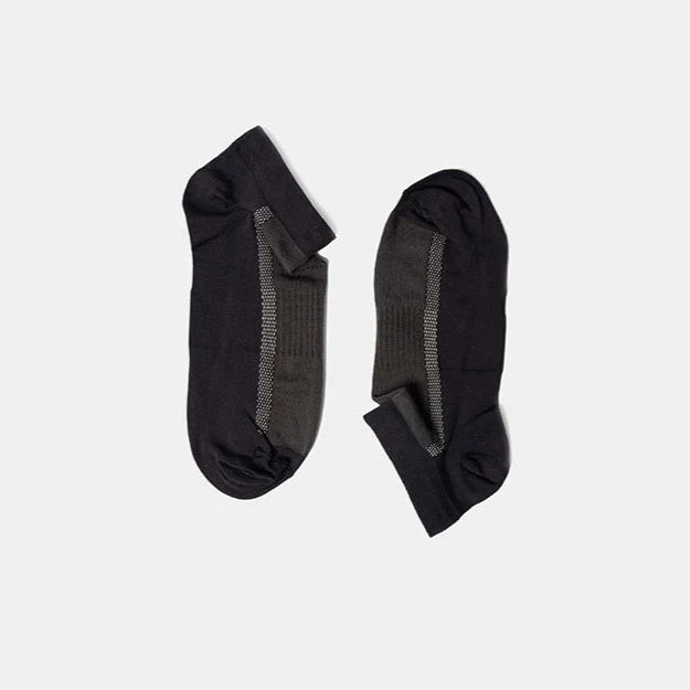 A pair of low-cut black and dark gray socks with a ribbed texture, laid flat on a plain light gray background.