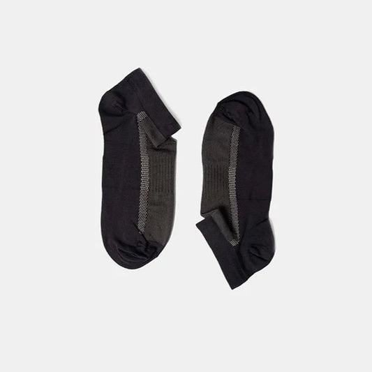 A pair of low-cut black and dark gray socks with a ribbed texture, laid flat on a plain light gray background.