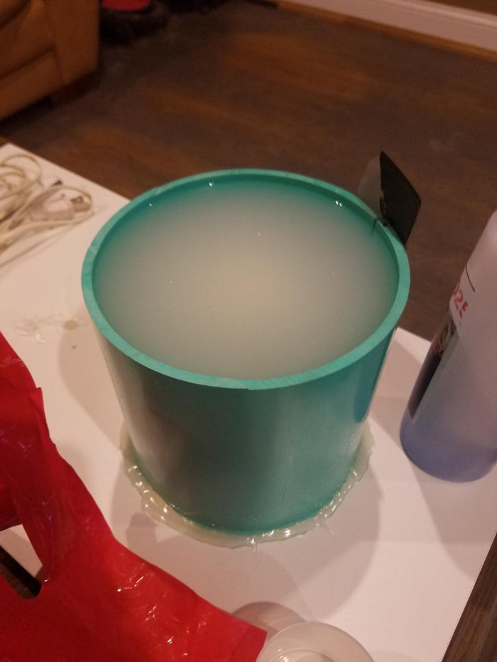 Blue green pot filled with silicone mold making material.
