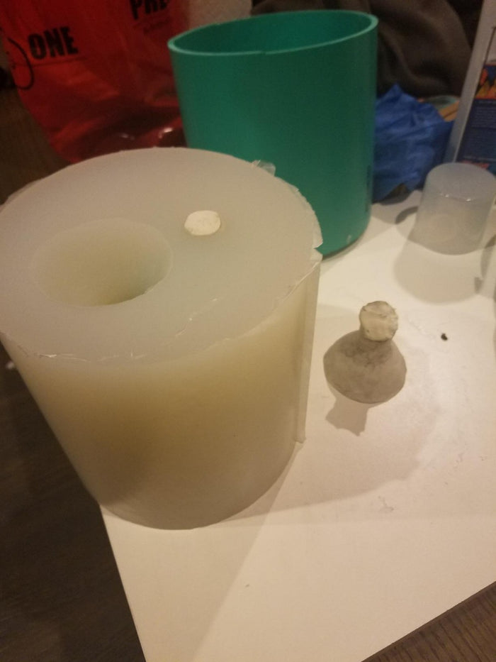 Cured Prosil 1025 silicone mold sitting in front of blue green pot.