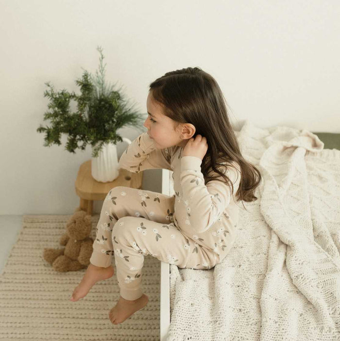 Girl wearing Petit Lem Gooseberry pajamas made from soft organically grown cotton rib.