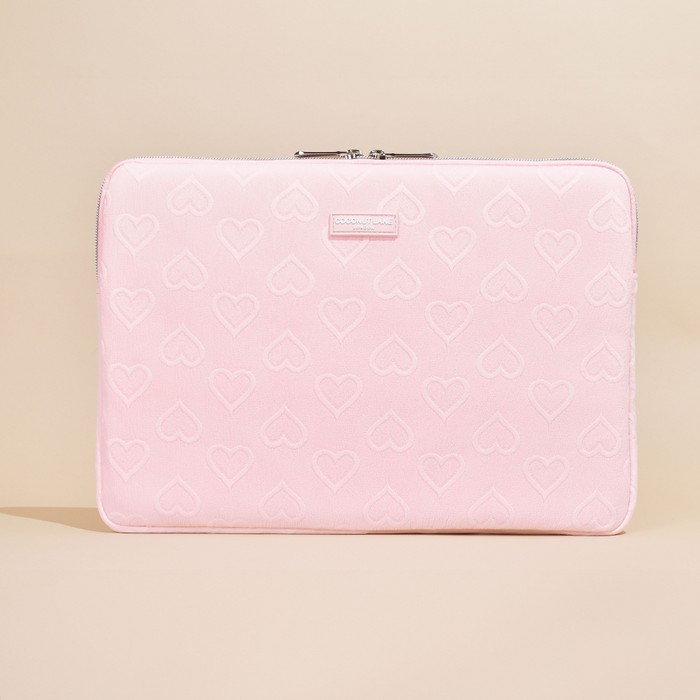 Baby pink laptop sleeve with subtle heart pattern and silver zipper.