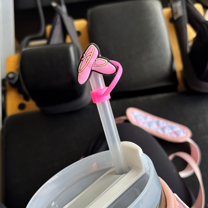 Pink ballet slipper-shaped silicone straw cover from Coconut Lane attached to a clear drinking straw.
