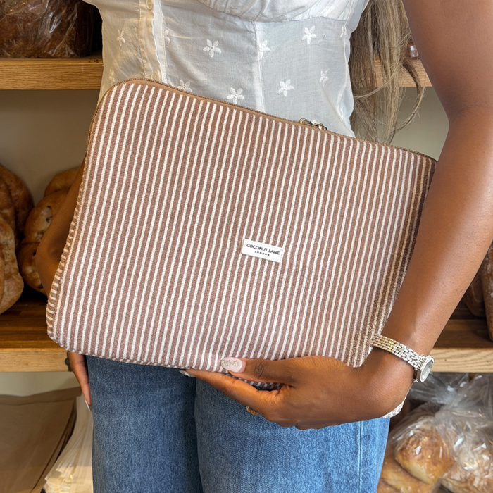 Girl stood in Notting Hill Bakery holding Chestnut Stripes Laptop Sleeve