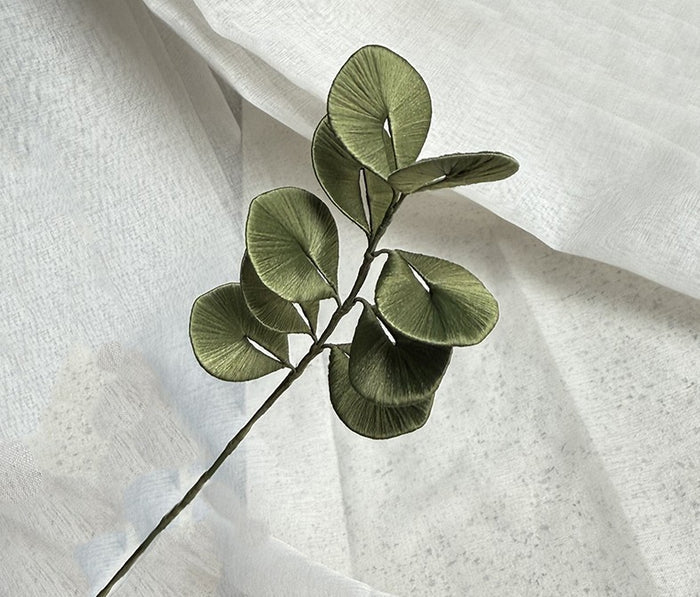 Finished silk-wrapped eucalyptus stem with green leaves, a handmade DIY flower project for home decor.
