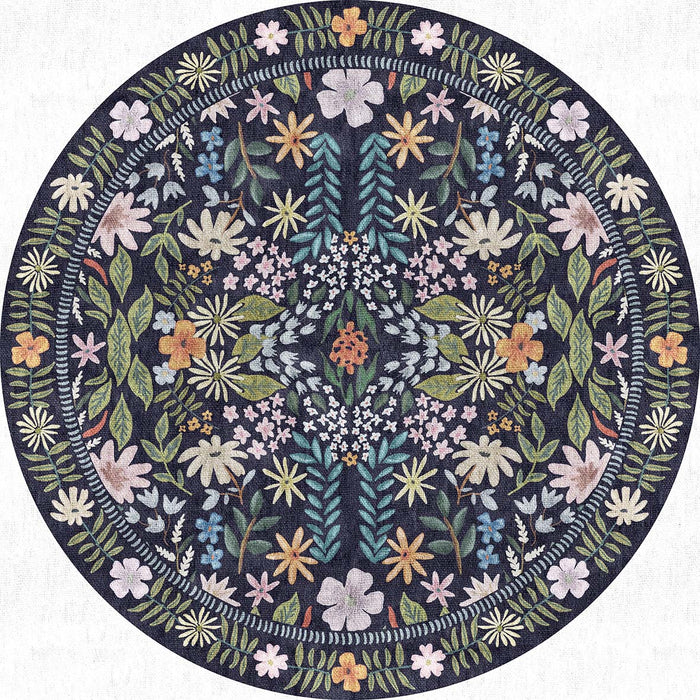 Round navy blue rug featuring a symmetrical botanical pattern of multicolored wildflowers and foliage.