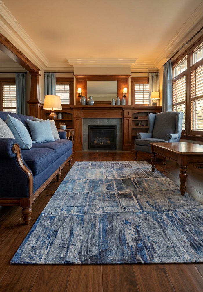 Blue and grey abstract patchwork rug in a traditional living room with wood trim and a fireplace.