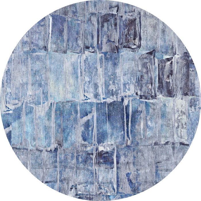 Circular rug with a blue and grey abstract grid pattern featuring distressed, painterly rectangular blocks.