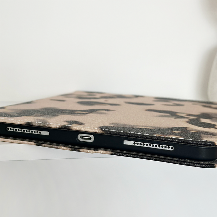 Coconut Lane Ivory Tort iPad case close-up with tortoiseshell pattern and visible cutouts for charging port and speakers.