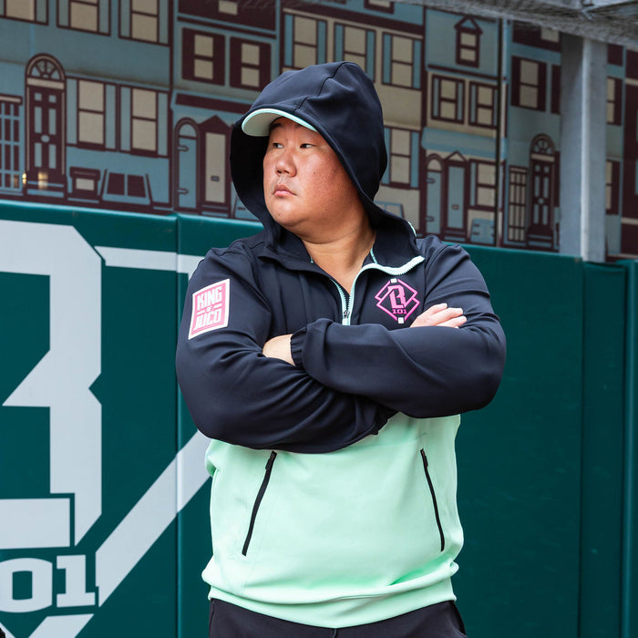 Adult model wearing teal quarter zip hoodie with "King Of JUCO" design