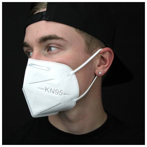 KN95 protective dust mask with no valve shown on man's face for size reference. Shows elastic straps and metal nose clip.