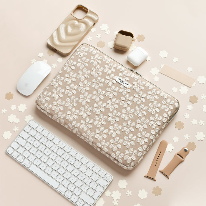 Mocha Flower laptop sleeve, phone case, AirPods case, and strap set on a light surface with mouse and keyboard.