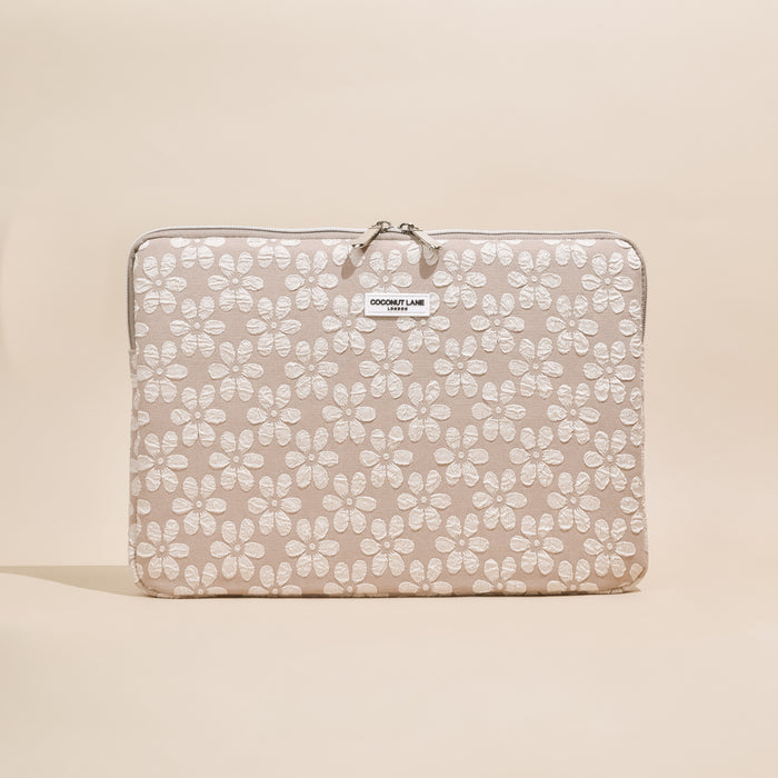Beige and white floral laptop sleeve with Coconut Lane logo patch.