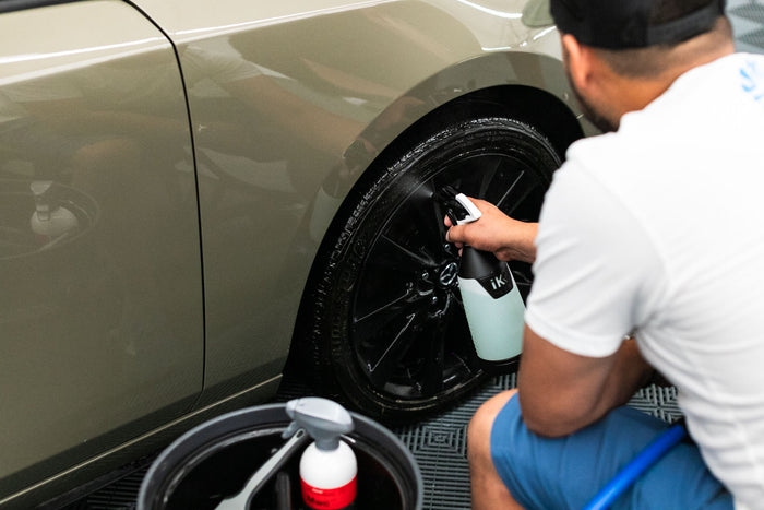 A person spraying KochChemie Multi Star from an iK Sprayer onto a car tire.