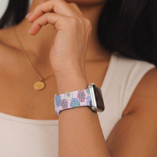 Woman in white tank top wearing a pastel floral Apple Watch strap by Coconut Lane.