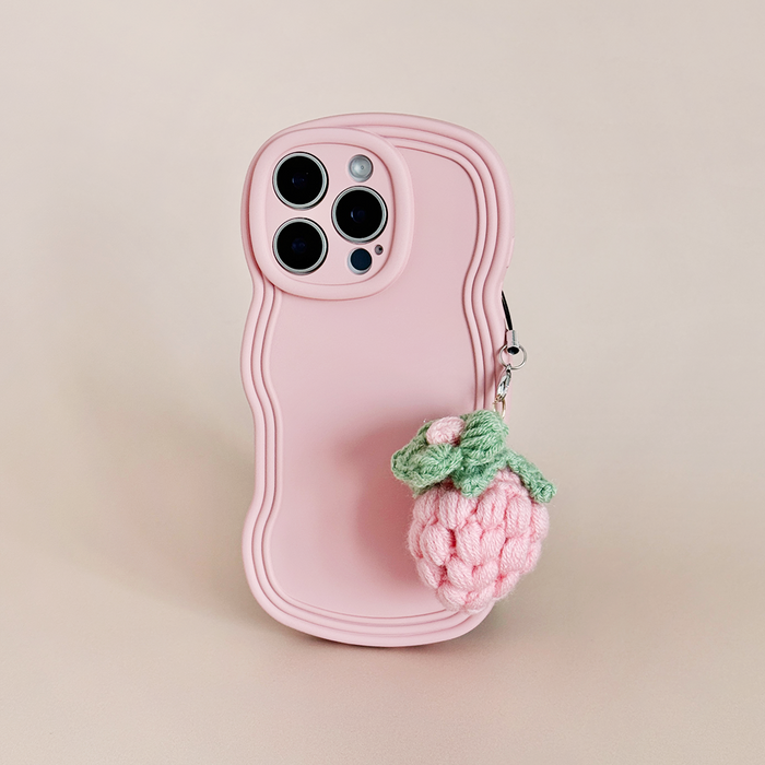 Pink phone with a wavy-edge case and Coconut Lane Pink Strawberry phone charm on a plain background.