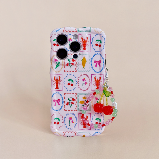 Phone with a vibrant case and Coconut Lane Red Cherry phone charm dangling from the side.