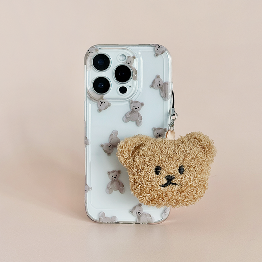 Teddy bear phone charm on a matching teddy bear case, both fluffy, set against a light pink background.