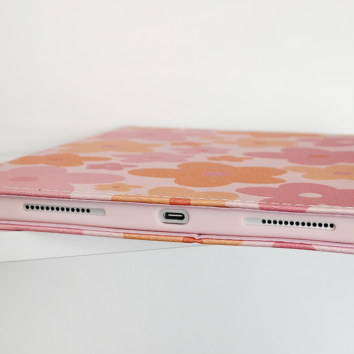 Coconut Lane iPad case in pink and orange floral pattern, showing charging port cutout and speaker grills.