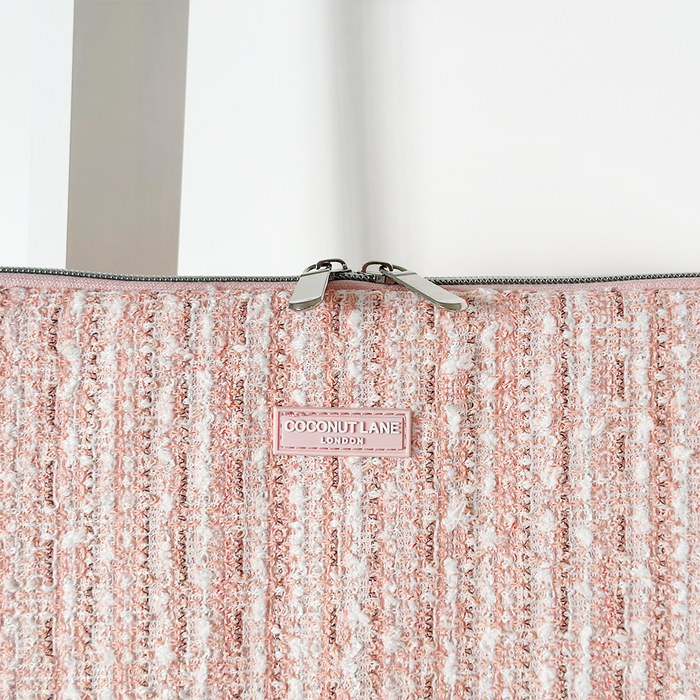 Pink textured tweed laptop sleeve with silver zipper pulls, shown on a white background.