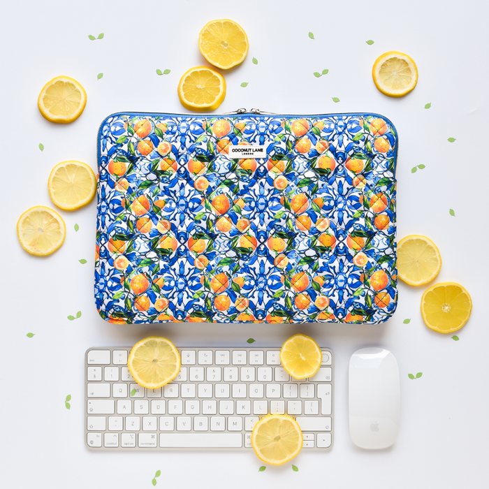 Quilted Coconut Lane laptop sleeve with blue and orange designs, lemon slices pattern, shown with keyboard and mouse.