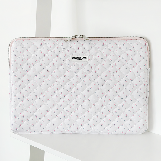 White quilted laptop sleeve with pink ditsy floral pattern and a zipper closure.