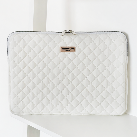 Quilted white laptop sleeve with coconut print, visible zipper, and a small Coconut Lane label on the front.