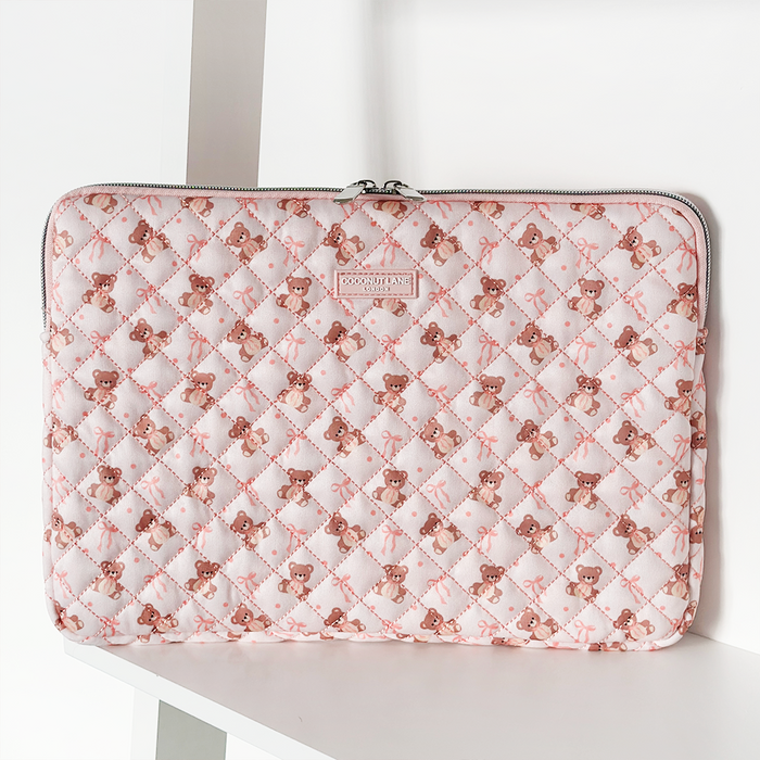 Quilted laptop sleeve with teddy bear and bow pattern, soft texture, from Coconut Lane.