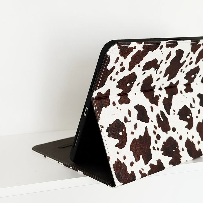IPad in a Rodeo Cowgirl patterned case by Coconut Lane, propped open on a white surface against a white background.