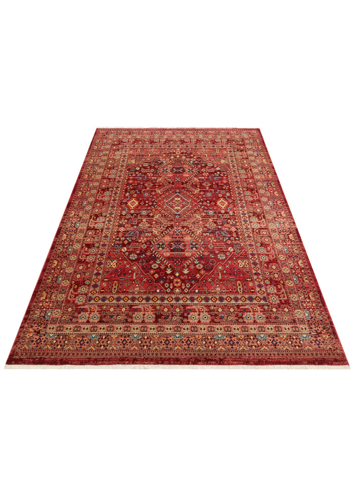 Red traditional rug with a central medallion, intricate floral motifs, and a geometric border on a white background.