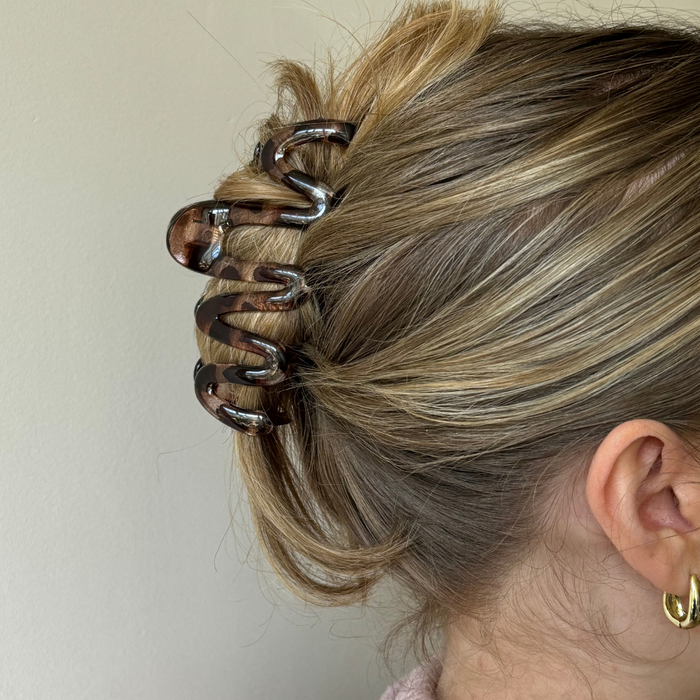Blonde hair secured with a Coconut Lane ivory tortoise-pattern squiggle claw clip.