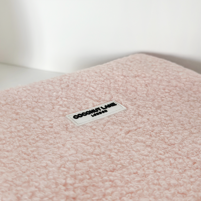 Light pink teddy-textured iPad sleeve with a small white Coconut Lane London label.
