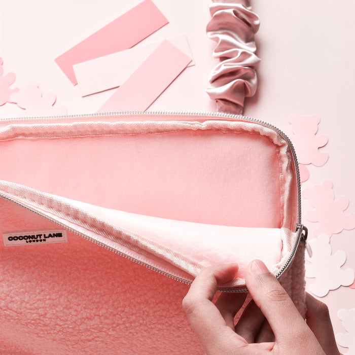 Hand opening pink Teddy Love-a-Lot laptop sleeve by Coconut Lane, shown on a pink background with paint swatches.