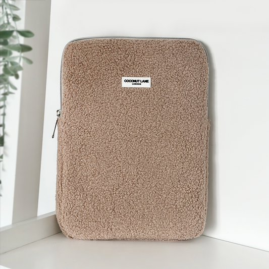 Beige fluffy iPad sleeve with a front label, shown standing upright.