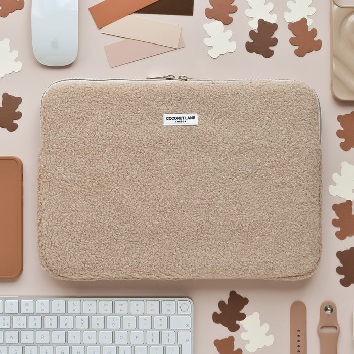 Teddy Rupert Laptop Sleeve by Coconut Lane with bear print, shown on a desk beside a keyboard, mouse, AirPods, and swatches.