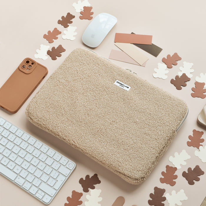 Brown Coconut Lane Teddy Rupert laptop sleeve on a desk beside a keyboard, mouse, phone, and bear-shaped paper cutouts.