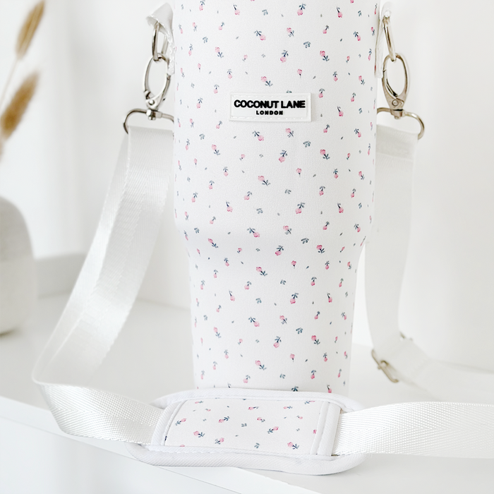 White Coconut Lane tumbler carry case with a ditsy floral pattern and adjustable crossbody strap.