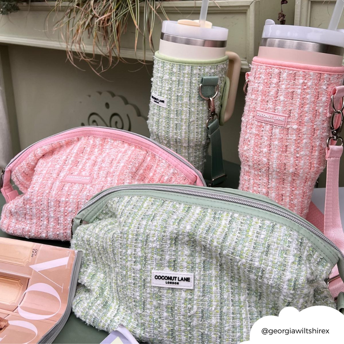 Pink textured tweed tumbler carry case, Stanley Quencher 40oz, and makeup palettes arranged on a tabletop.