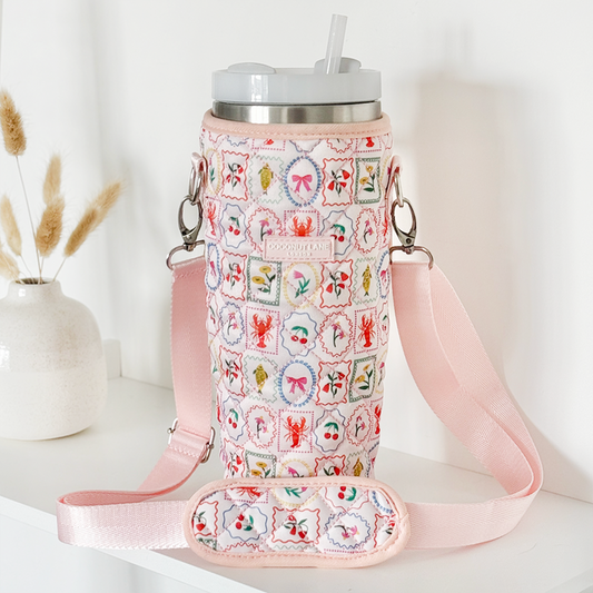 Quilted Dolce Vita Coconut Lane tumbler carry case on a shelf beside a vase of dried flowers.