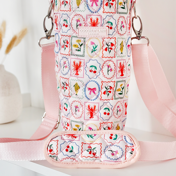 Quilted Dolce Vita tumbler carry case with pink strap and printed accents.